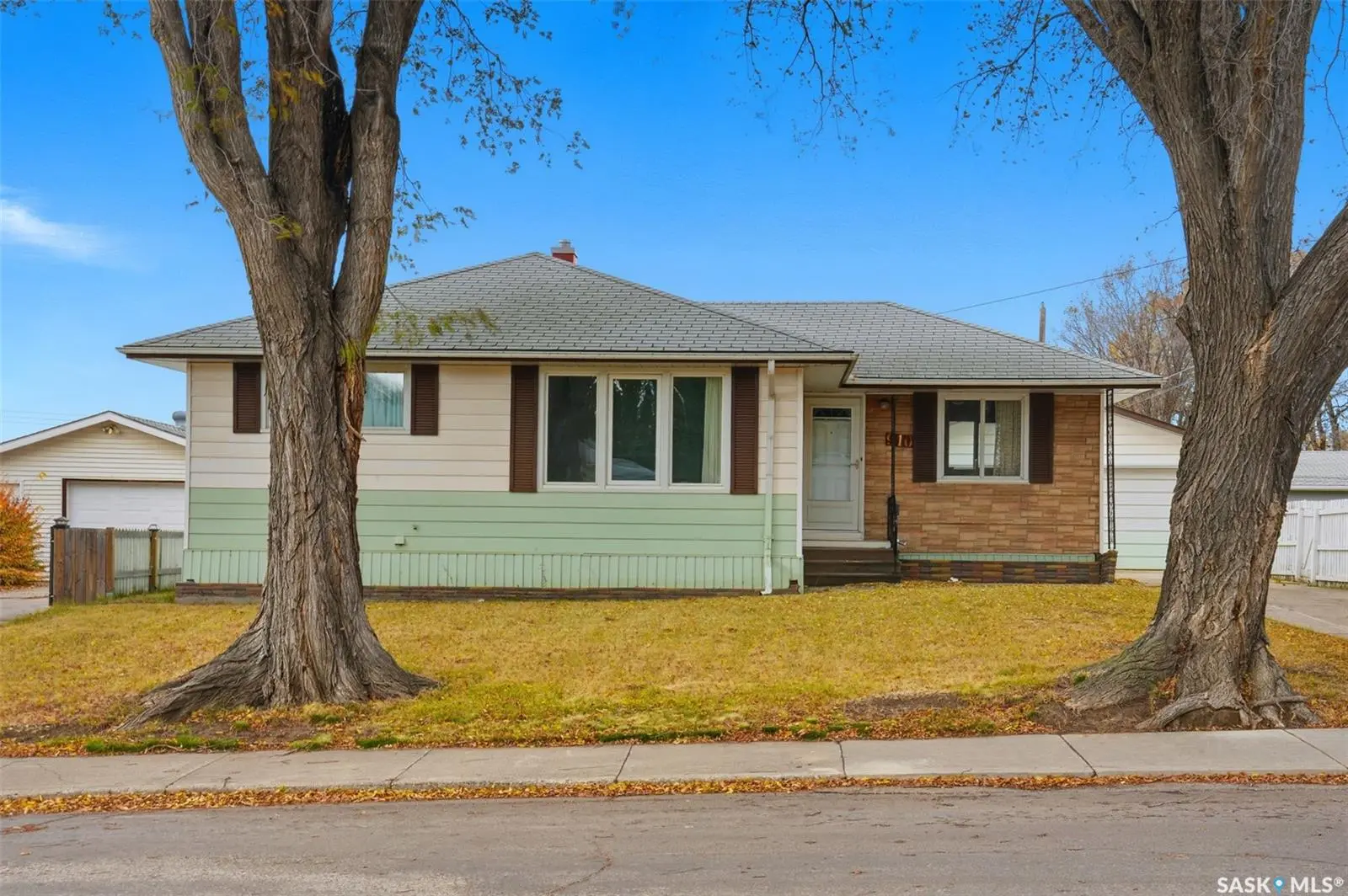 Exterior photo of 910 35th Street W, Saskatoon SK — mid-century bungalow backing Henry Kelsey Park in Hudson Bay Park.
